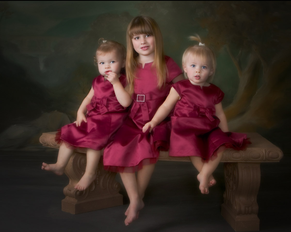 Studio Portrait of Three Sisters Studio portrait of three sisters in coordinating burgundy dresses