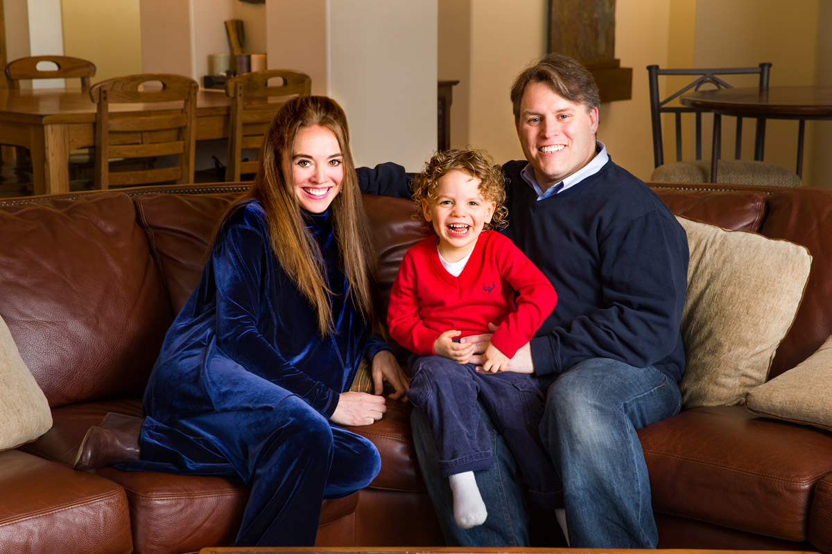 Parents and young child photographed together in their home